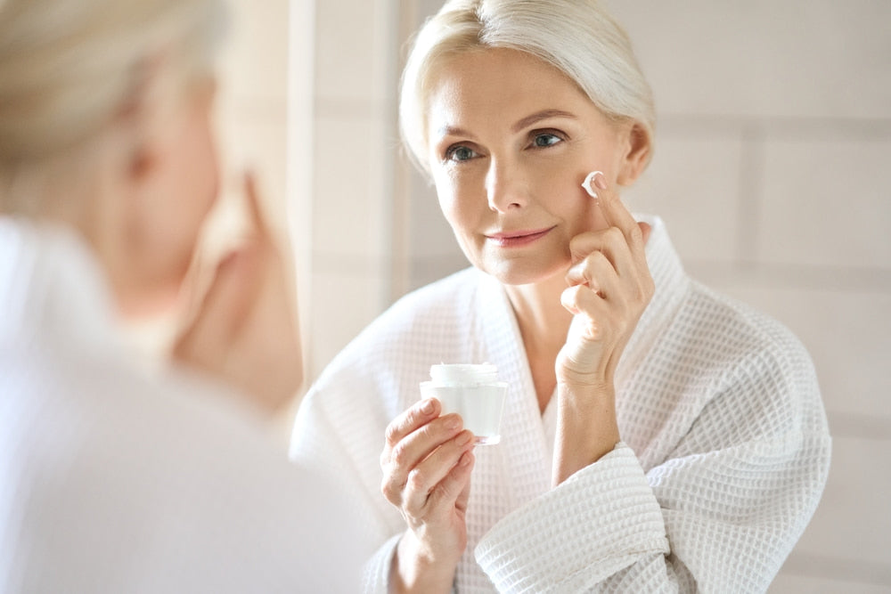 A woman putting cream on her face