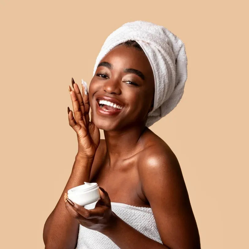 A woman putting cream on her face